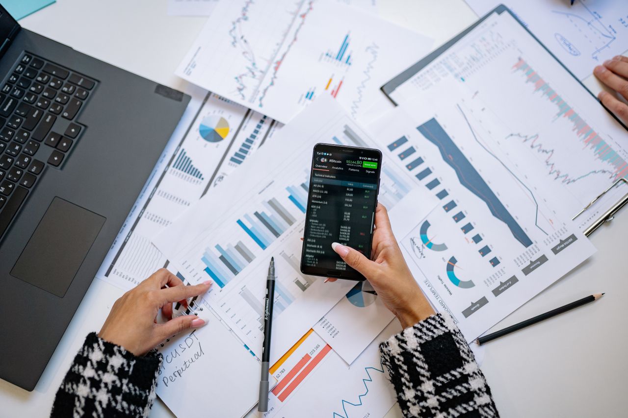 who-we-are A top view on charts and smartphone in an office, showcasing data analytics.